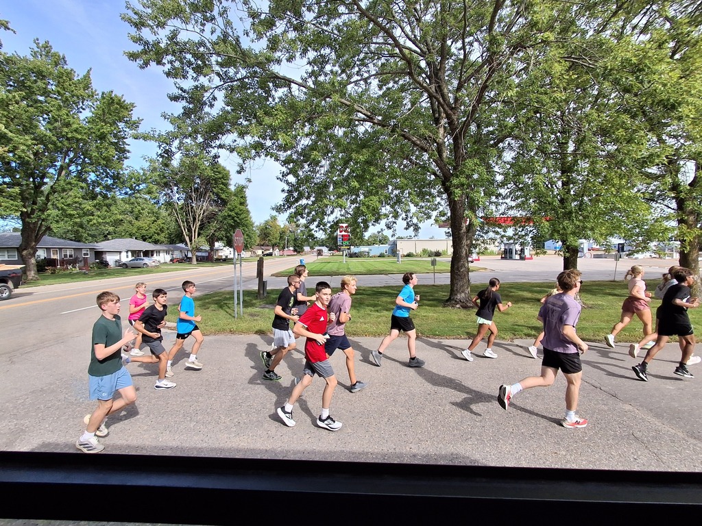 Cross Country team runs the football to Wilson Field