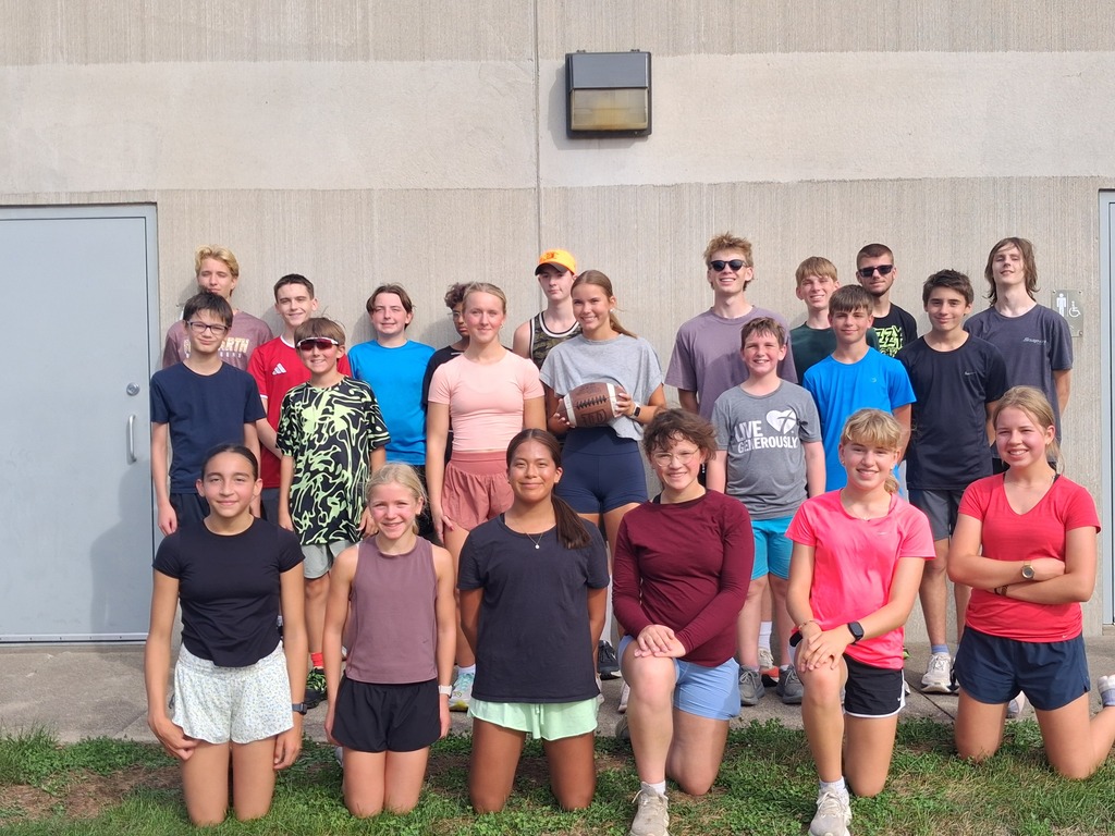 Cross Country team runs the football to Wilson Field