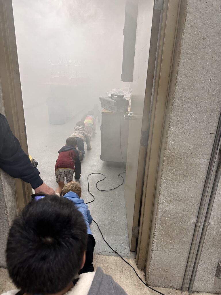 Kids crawling through a smoke filled room