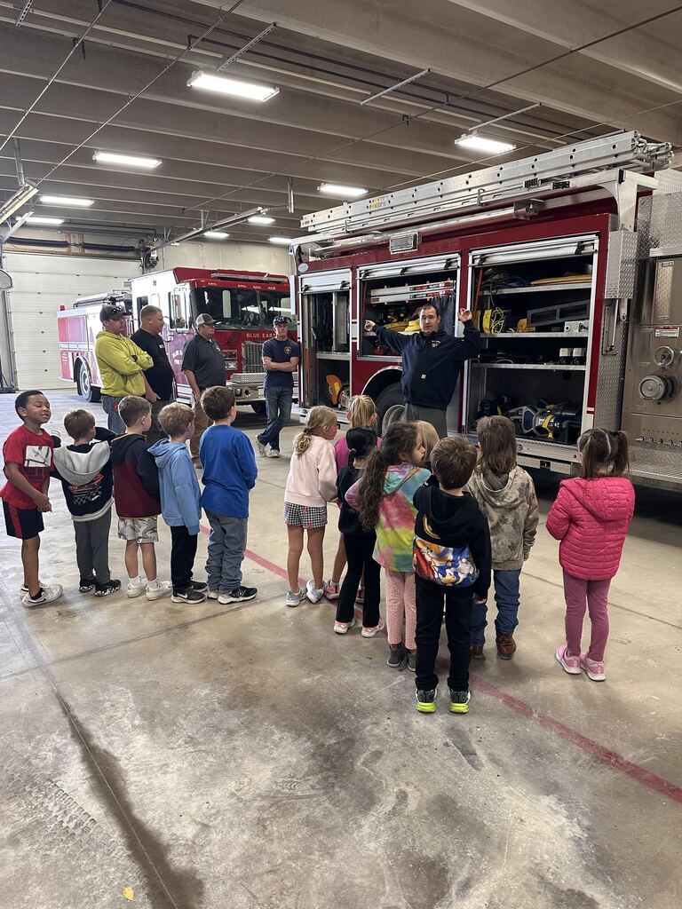 A group of kids learning about the different parts of the fire truck