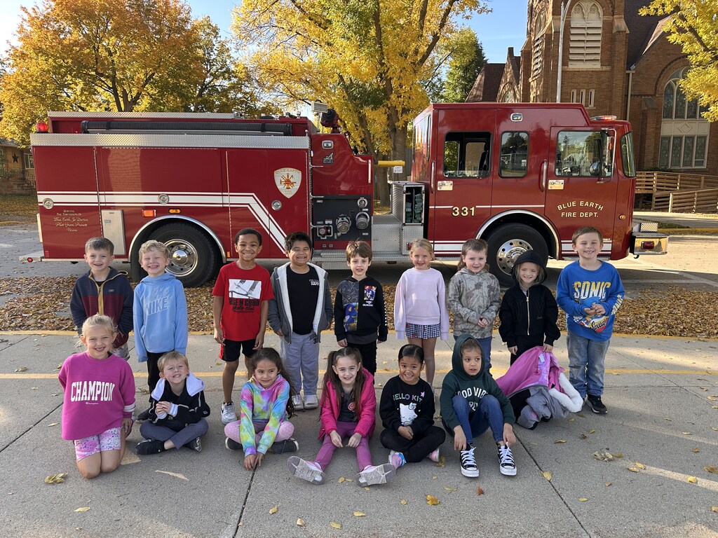 Kids standing in front of a firetruck