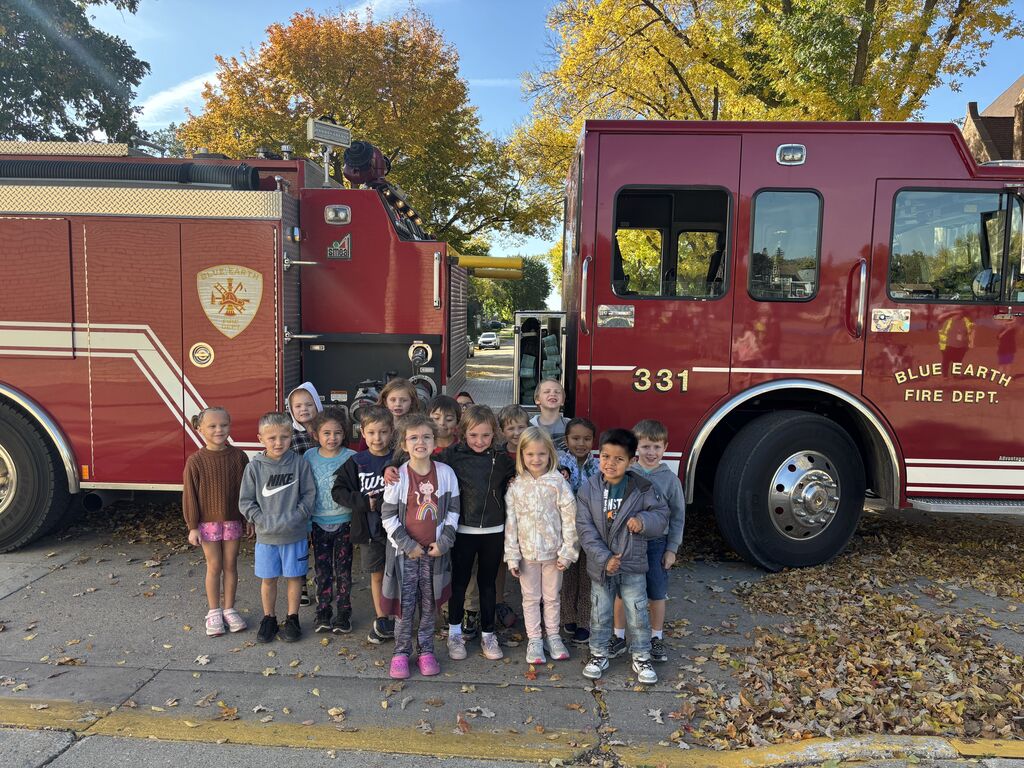 Kids standing in front of a firetruck