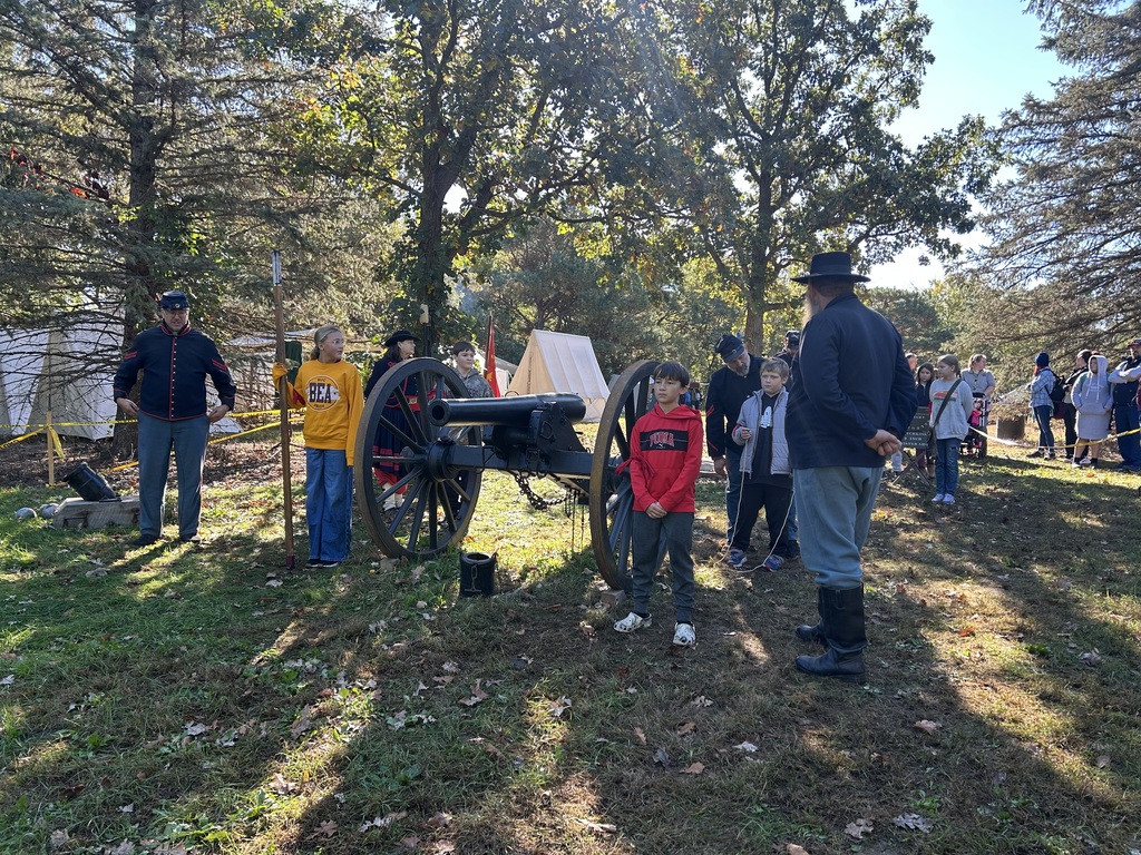 A couple of standing near a cannon