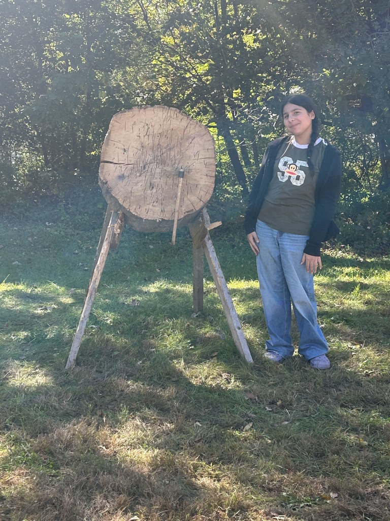 A student standing in front of where she throw an axe