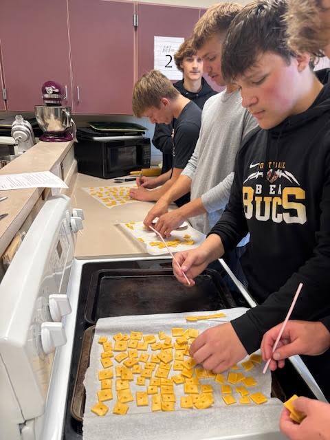 A student poking holes into the cracker dough