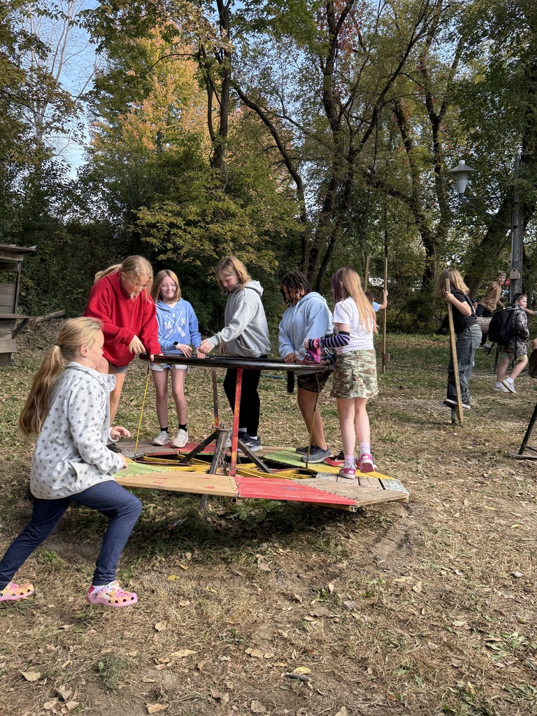 A group of girls playing on an old merry-go-round.
