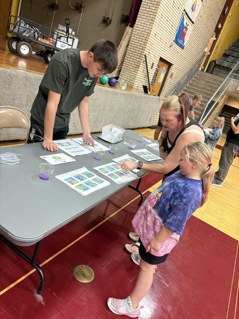 A mom and daughter playing a math game with a high schooler