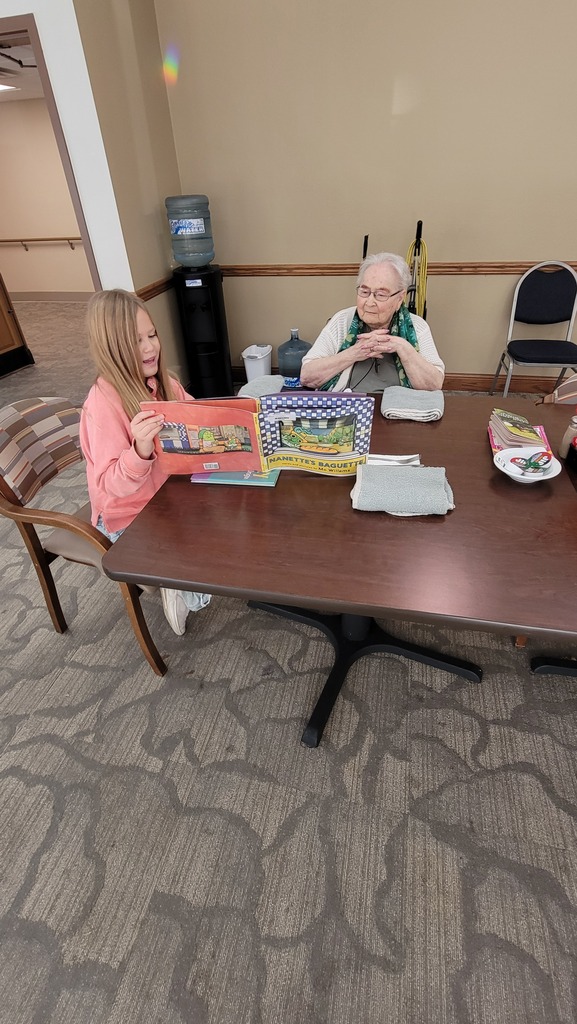 A student reading to a resident at Parker Oaks