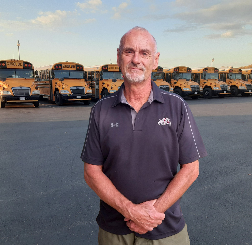 Bus driver in front of buses.