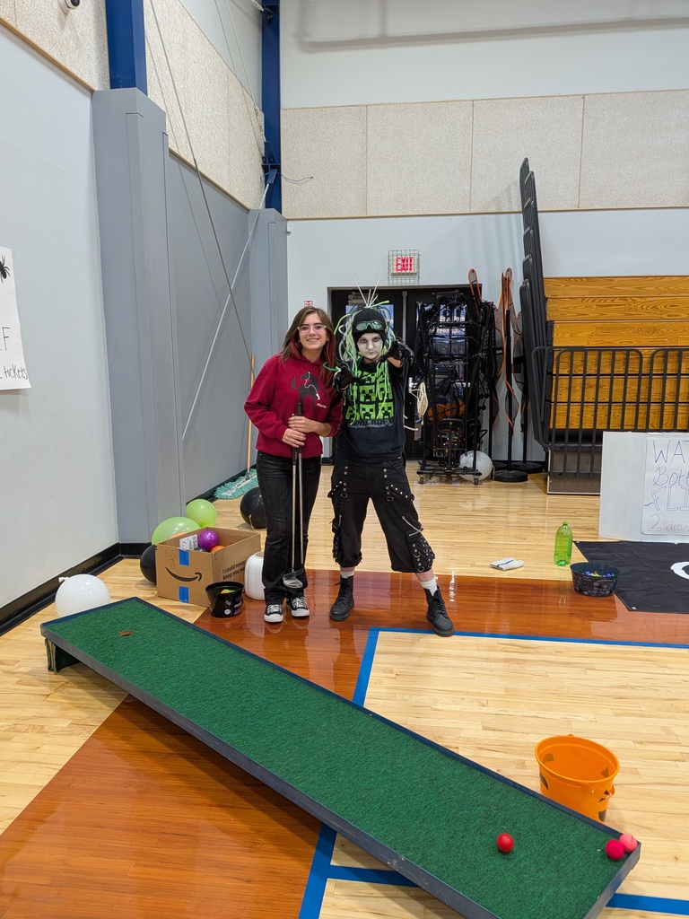 Renaurd and Kylie help with the bottle toss game and the miniature golf 