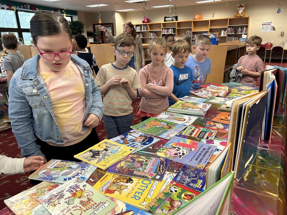 Students at book table looking over books for sale