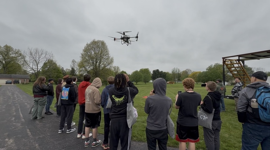 students watching a drone fly