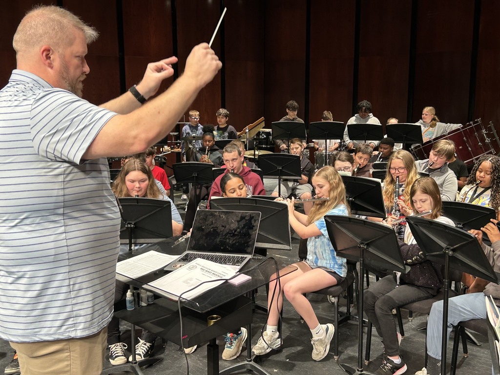 Mr. Linko leading the group of students playing their band instruments