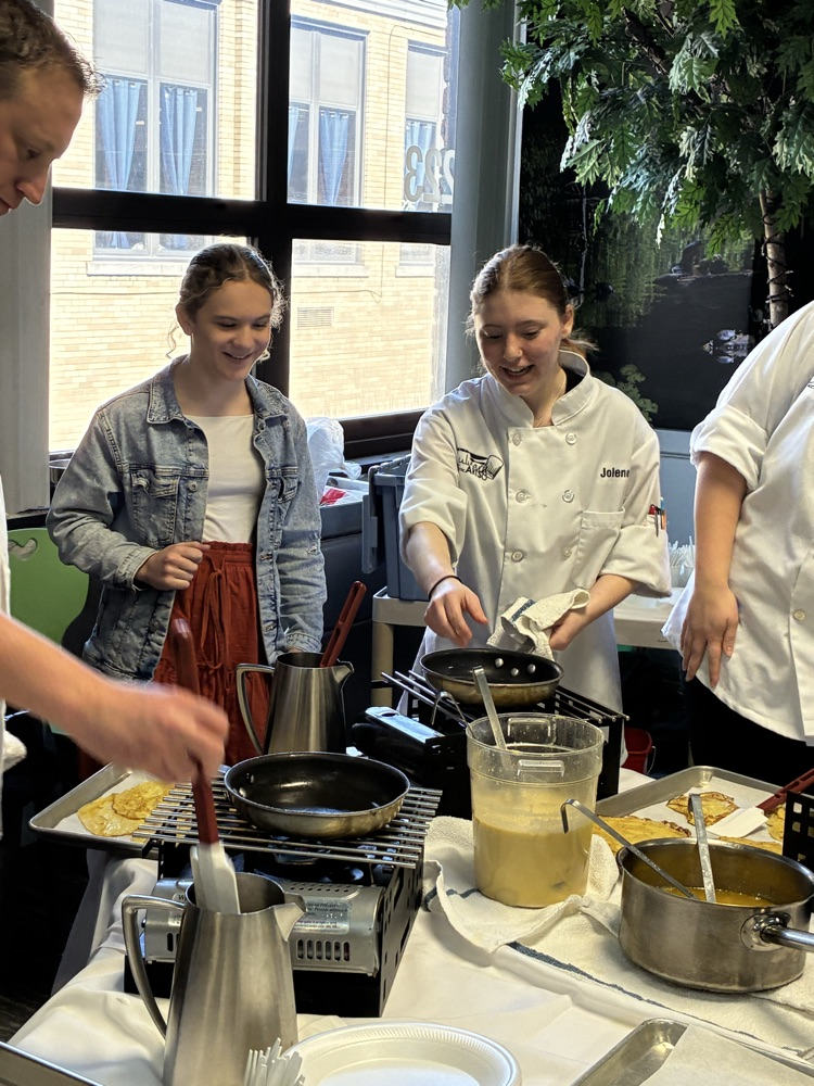 a student making crepes in chef presentation
