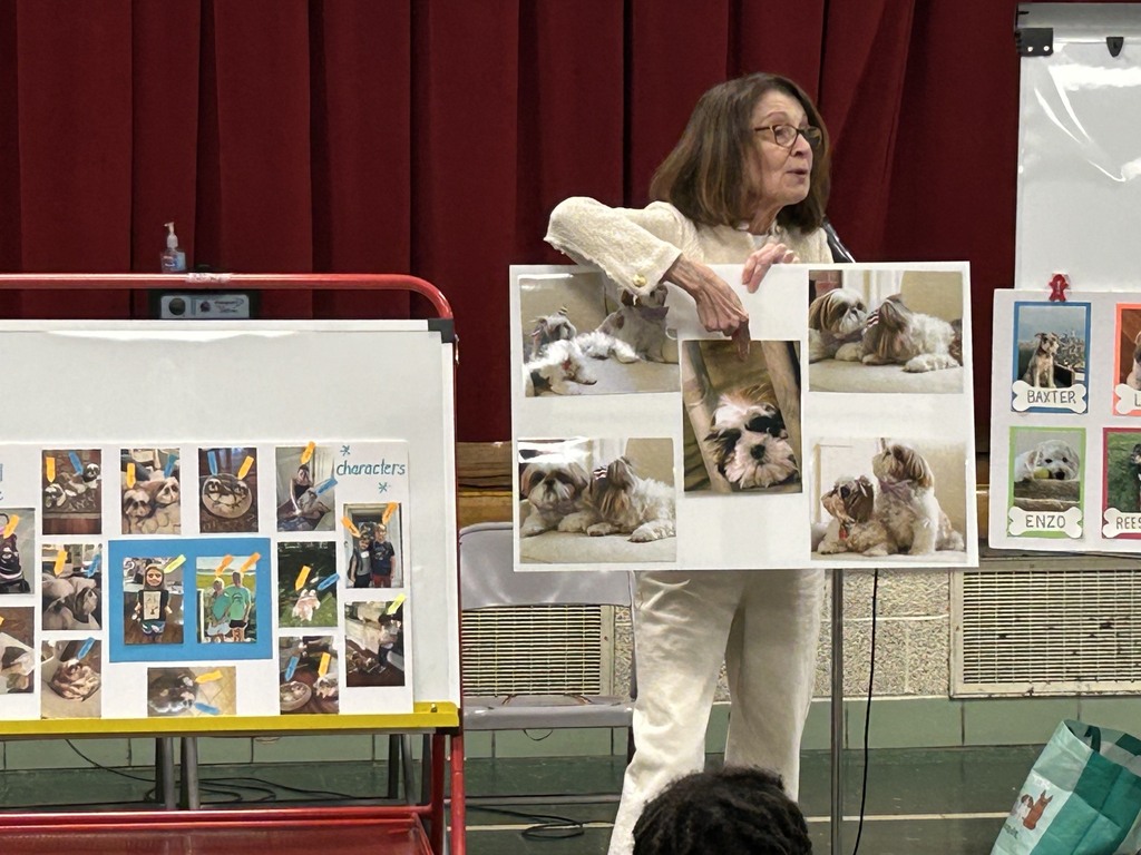 Author Linda Krieger holds up poster board of her real dog characters