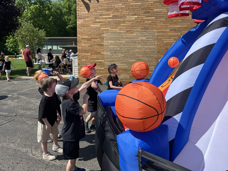 kids shooting baskets at basketball inflatable
