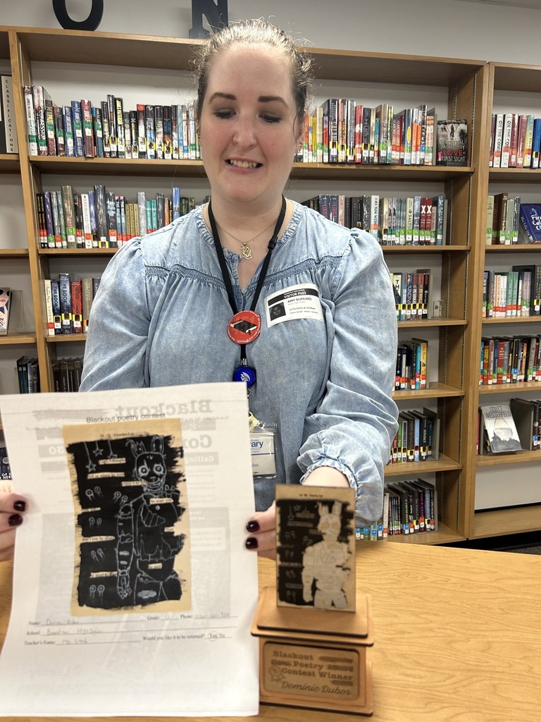 Librarian holds other Art Connects to Poetry Winner poem and laser engraved replica.