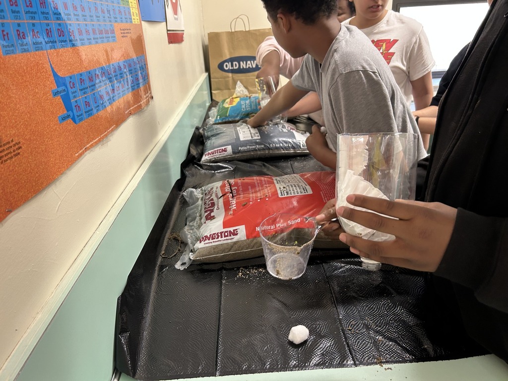 students choosing how much sand, stones, or cotton to use to make their water filtration system
