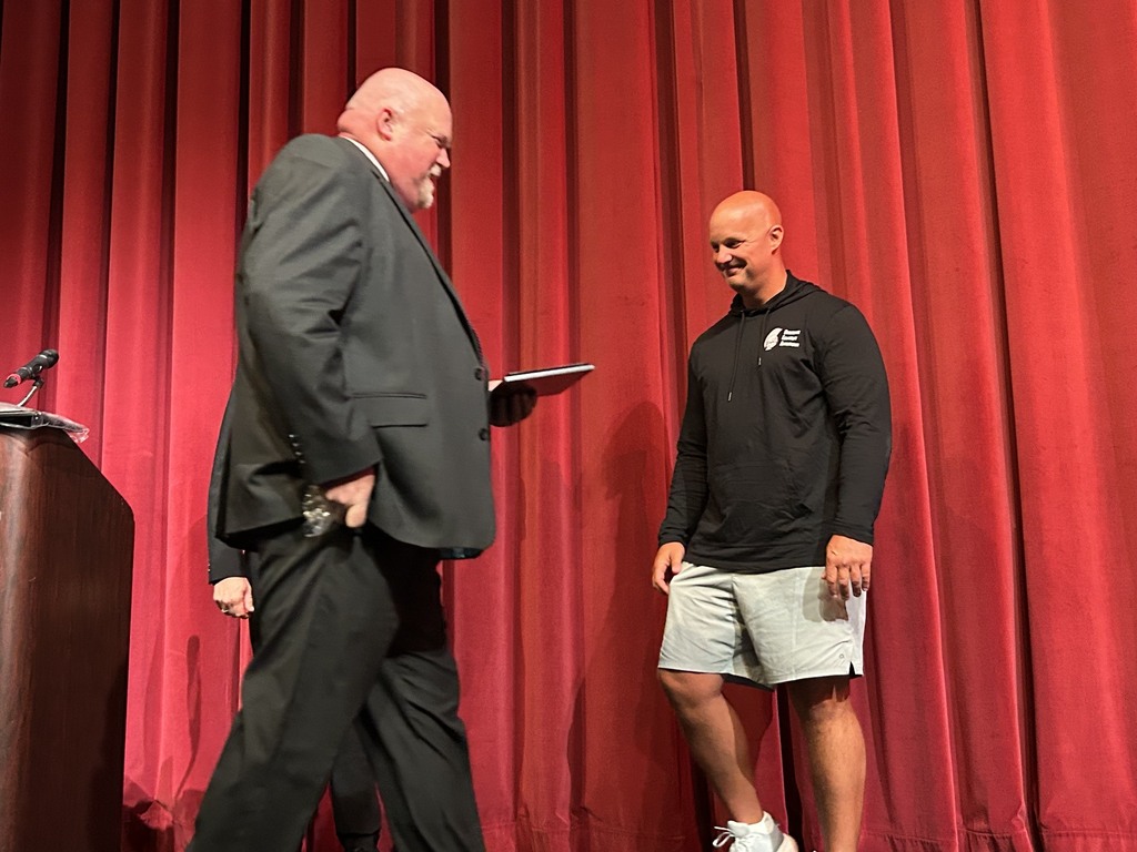 Superintendent Neifer giving Andy Wade his 25 year award on stage