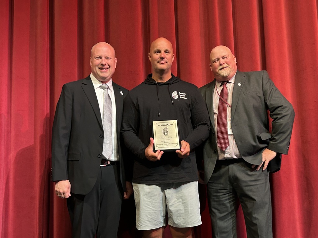Dr. Zura, Andy Wade, Superintendent Neifer on stage with Andy's 25 year award