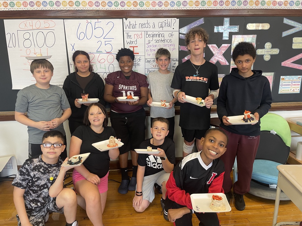 6th graders holding their hand made volcanos