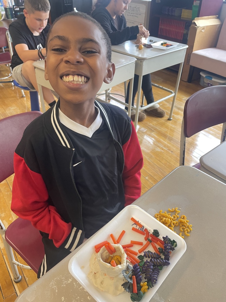 boy with a great smile with is hand made volcano 
