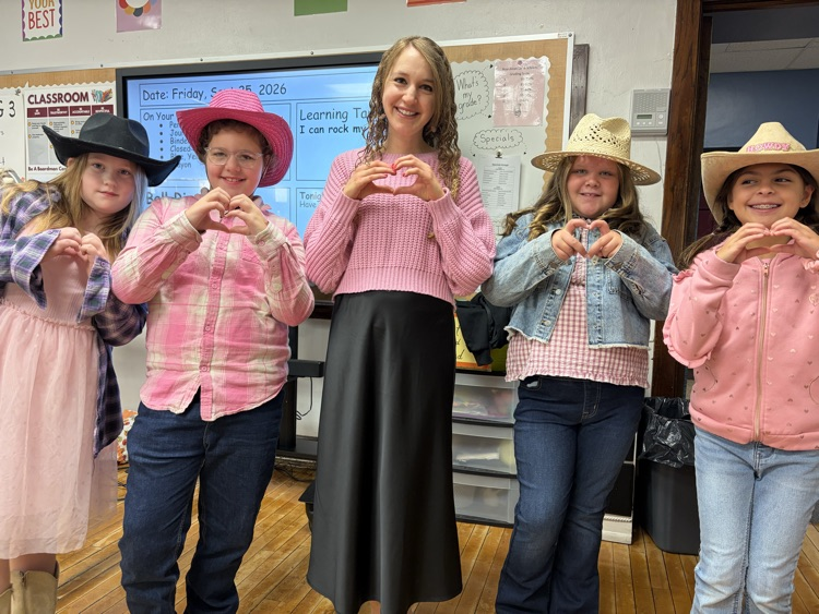 students dressed for Dolly day with hands signing a heart shape