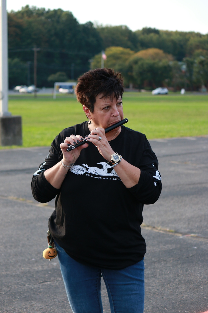 alumna playing picolo in the parking lot where they held practice