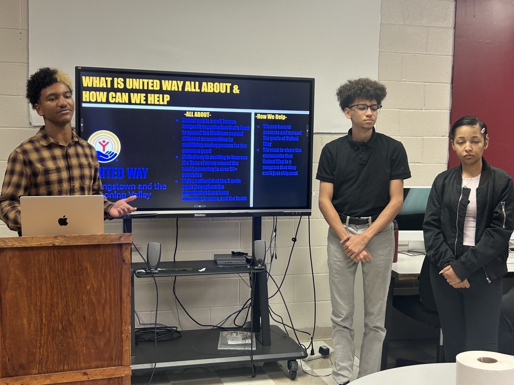 3 students with presentation What is United Way All aBout & How Can we help