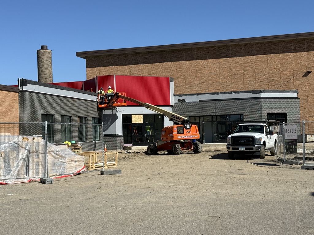 Construction workers adding red tin to the new main entrance at BOLD School. 