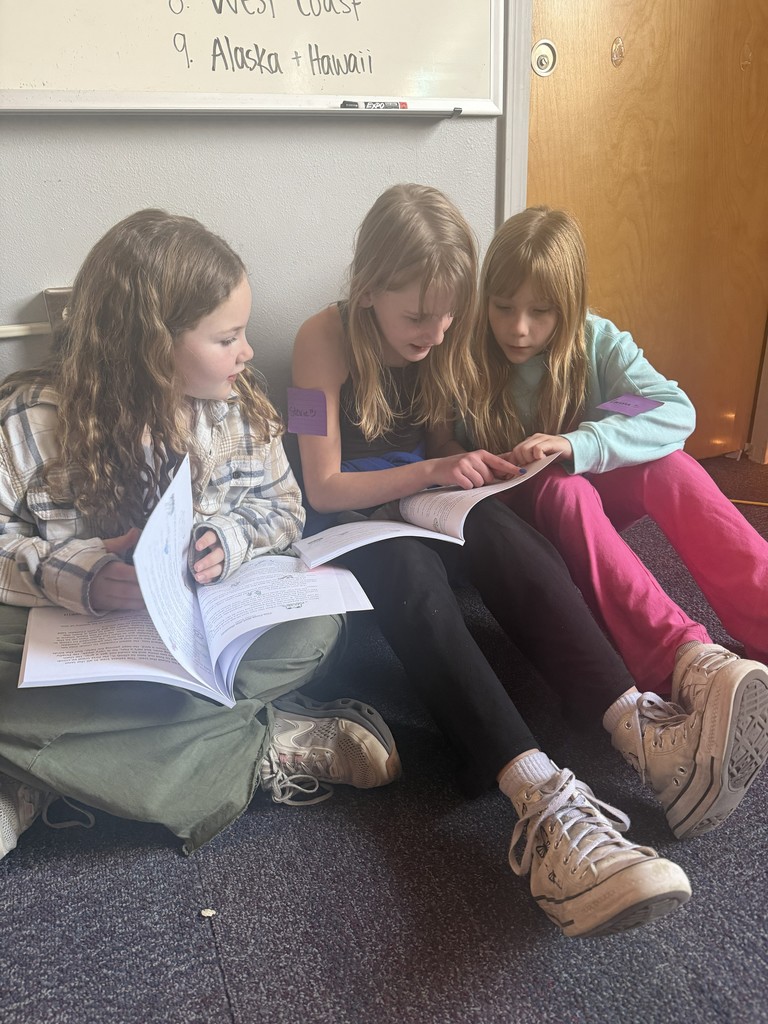 Three students reading their books together.