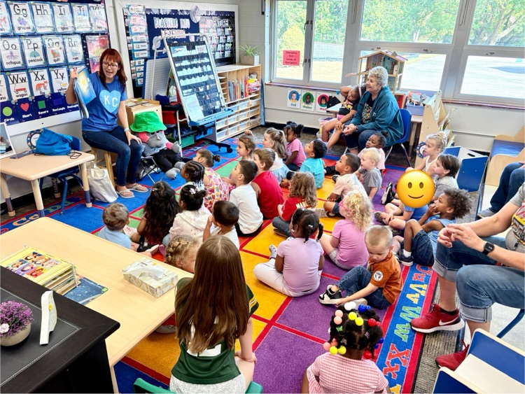 Miss Leslie and Hollywood, the monkey, reading to the classroom.