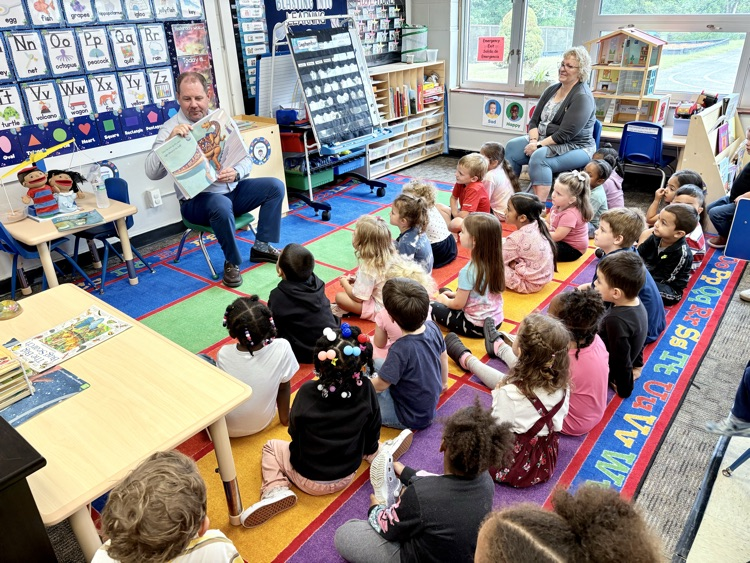 superintendent moulin reading a book to the class