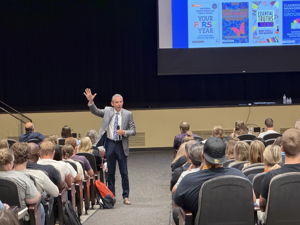 Educator and author Todd Whitaker speaking to USD 204 staff during a professional development session, standing in front of a screen displaying his books.