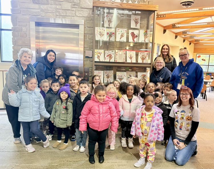 kids stand in front of the art work they made for the Boo Bash