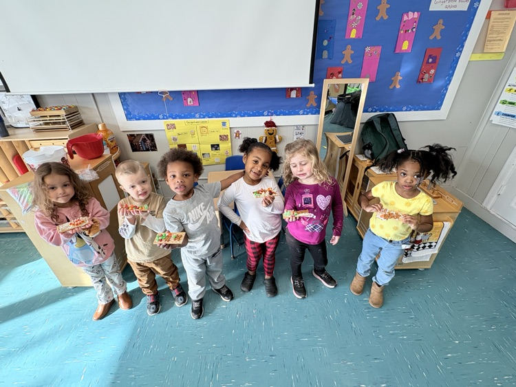 kids hold up gingerbread house