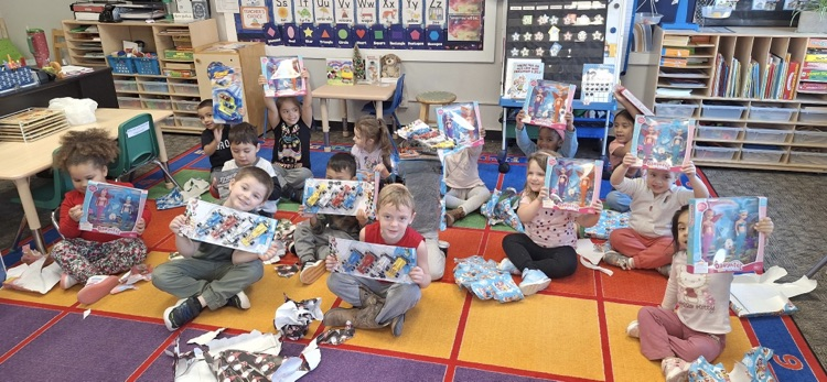 kids hold up opened gifts