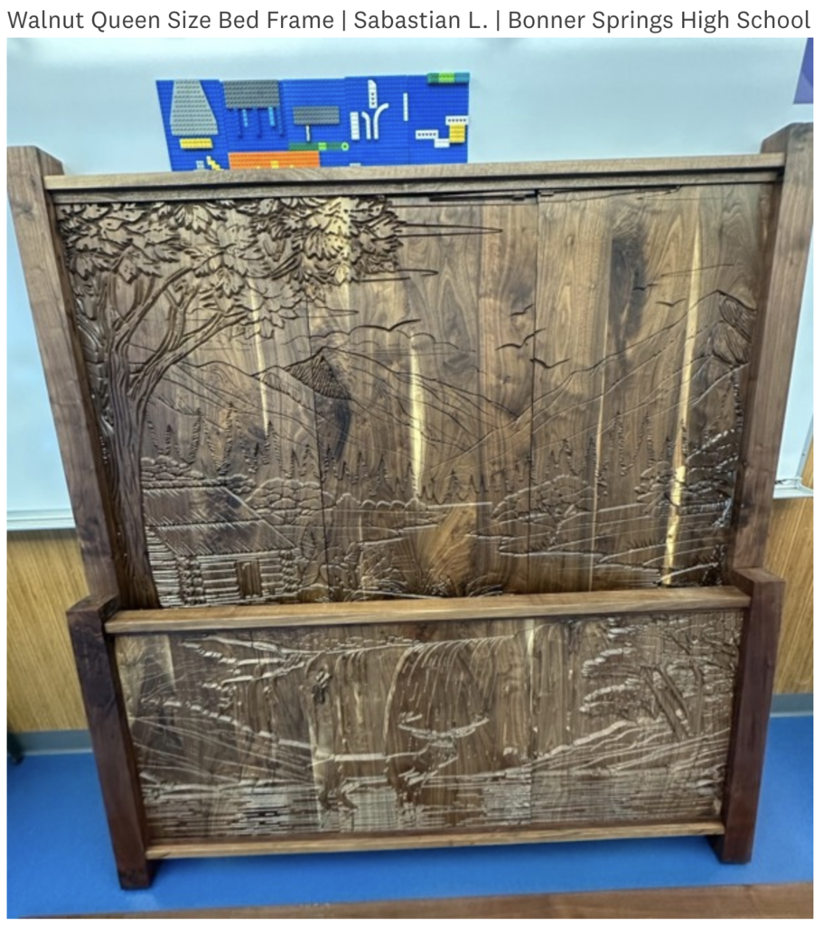 A walnut bed frame displays a detailed carving of a forest landscape, set against a blue background.