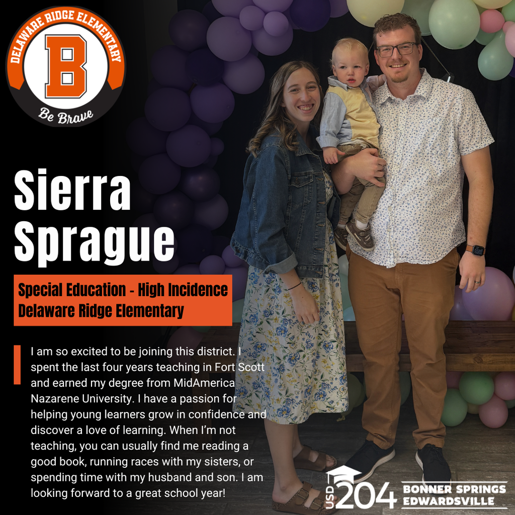 A man and woman hold a baby in front of balloons. The man wears glasses and a watch.