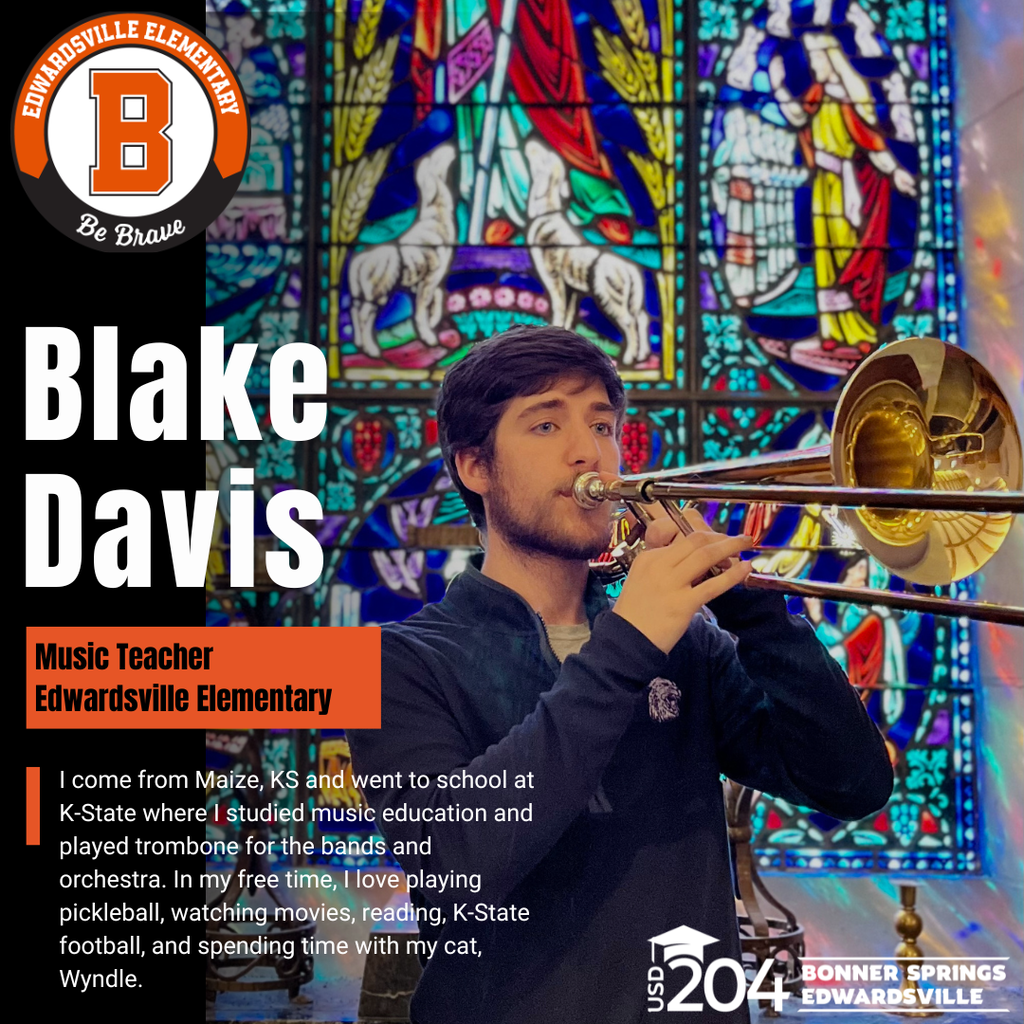 A man plays trombone, standing in front of a stained glass window with a horse and other designs.