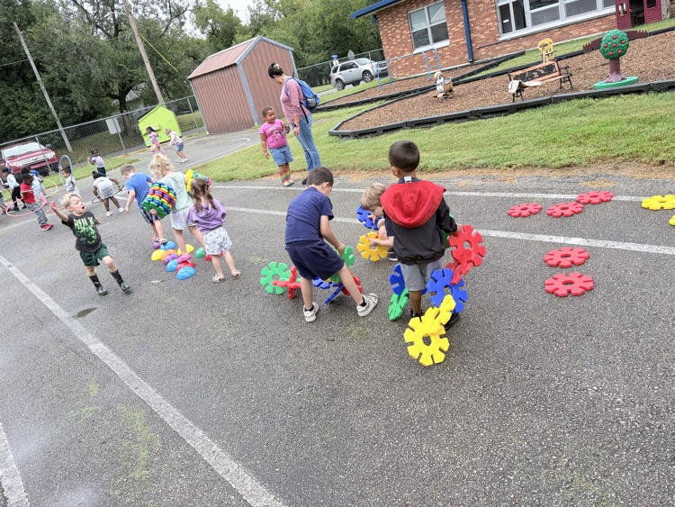 kids play outside with blocks on a wet day 