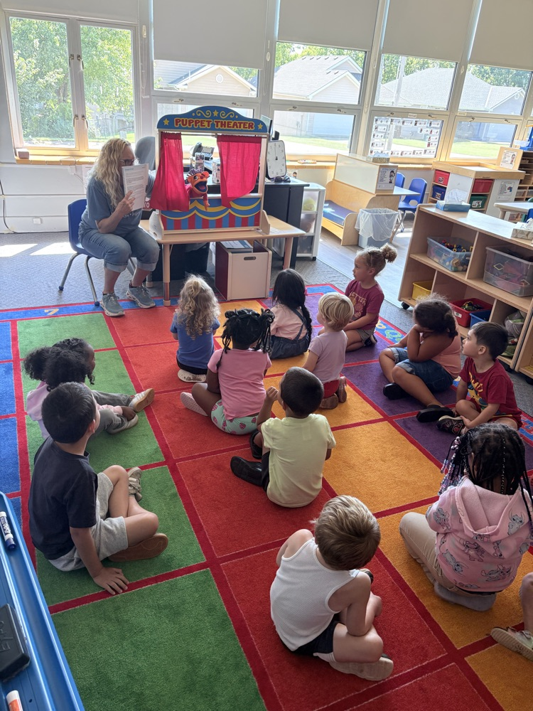 kids sitting a listening to a hand puppet who talks about feelings and ways to be a good friend 