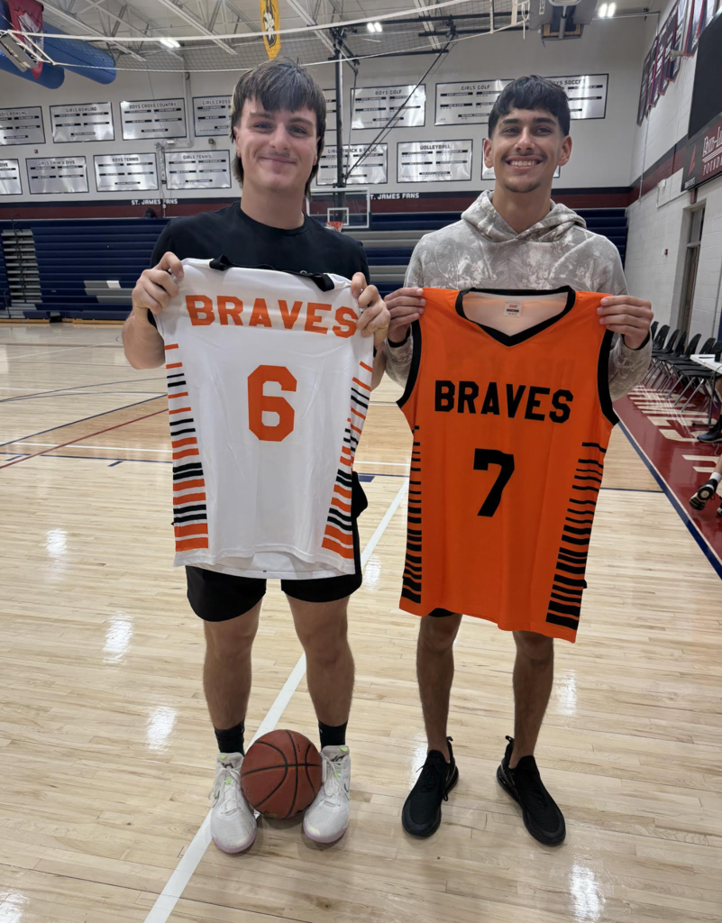 Two young men stand on a basketball court, each holding a jersey with the word "Braves" and numbers 6 and 7.