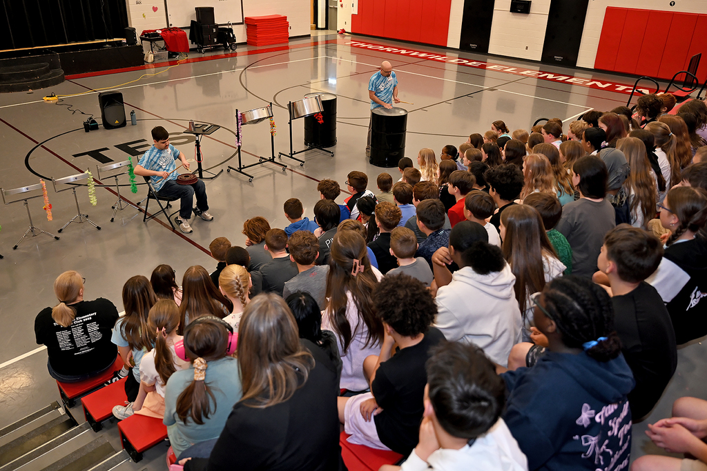 students watching people playing steel drums
