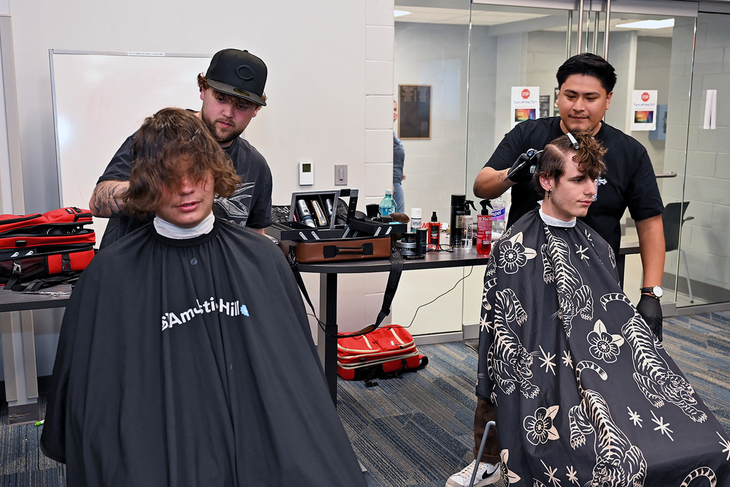 two students getting hair cuts