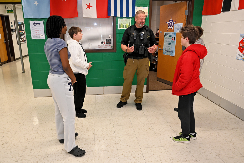 Deputy Menefee speaking with four students