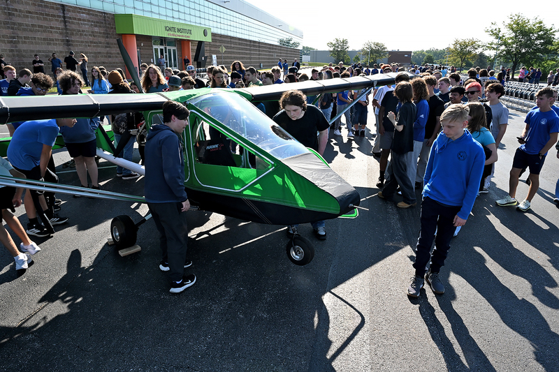 students looking at airplane
