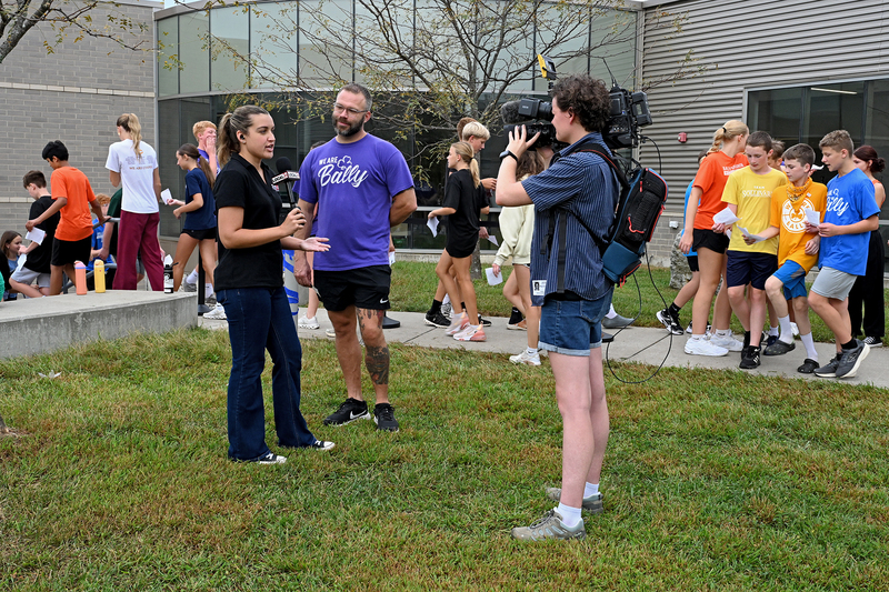 television crew interviewing teacher