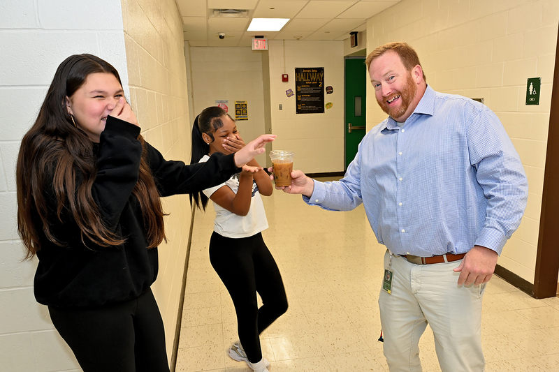 students giving teacher a coffee
