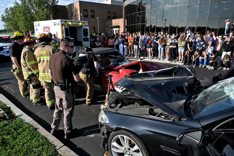 emergency workers and students at simulated car accident